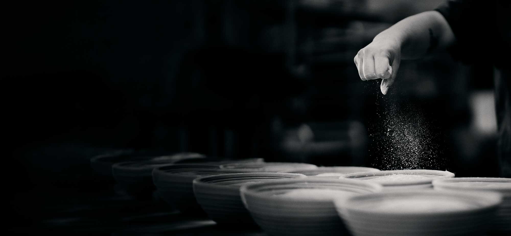 Baker dusting flour through the air