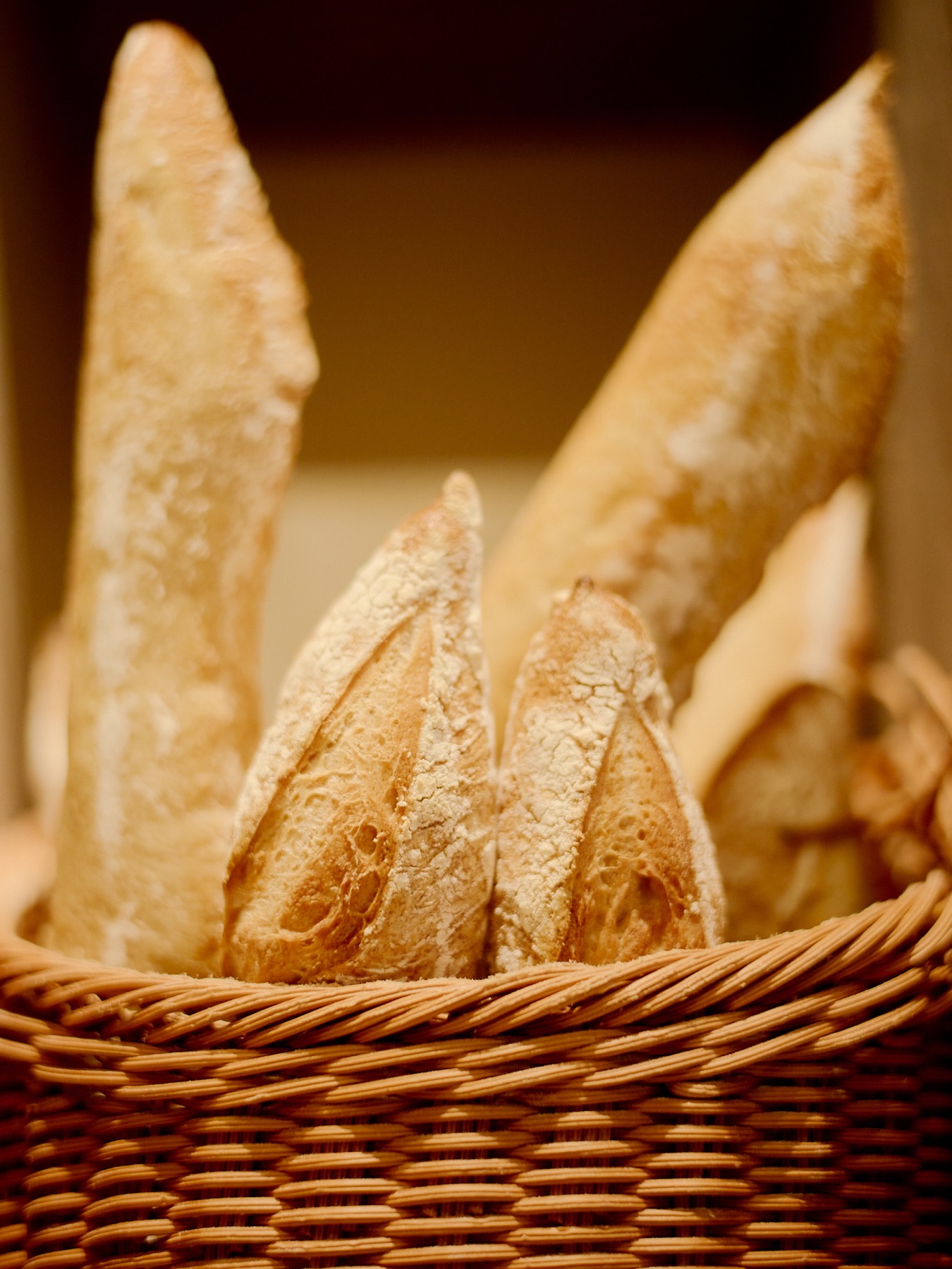 Fresh baguettes arranged in a wicker basket